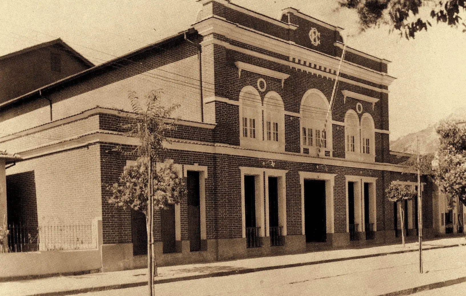 Edifício clássico com portas e janelas abertas, em tons de sepia.