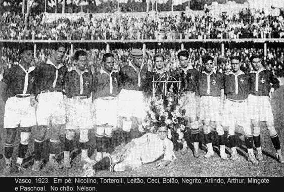 Equipe de futebol em 1923, com troféu e jogadores em uniforme tradicional.
