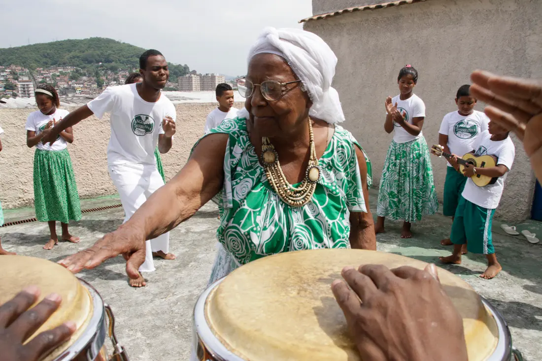 Grupo de pessoas reunidos em celebração cultural ao ar livre.