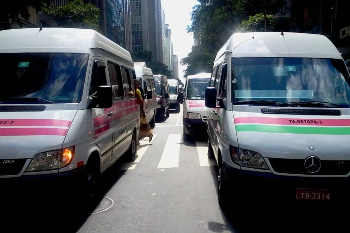 Uma rua movimentada com veículos e pedestres.