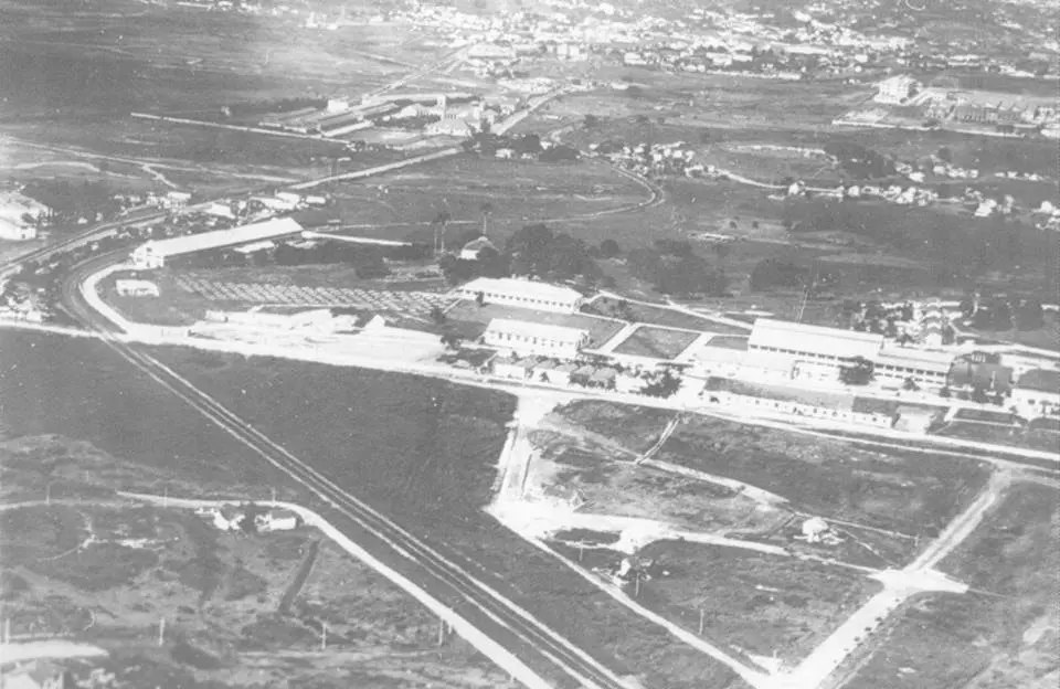 Área urbana com trilhos ferroviários e edifícios industriais.