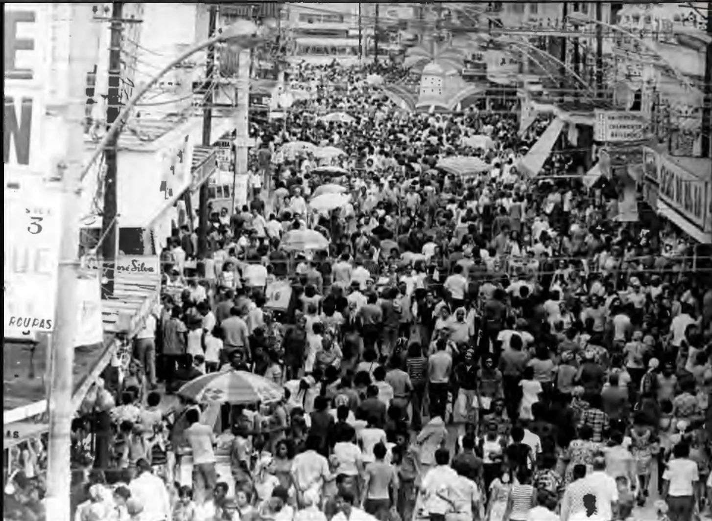 Foto em preto e branco de rua comercial de Madureira tomada por multidão.