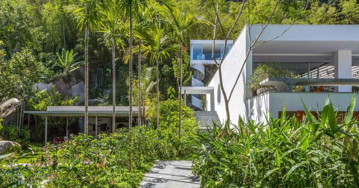 Ambiente natural e arquitetônico com floresta, edifícios e vegetação verde.