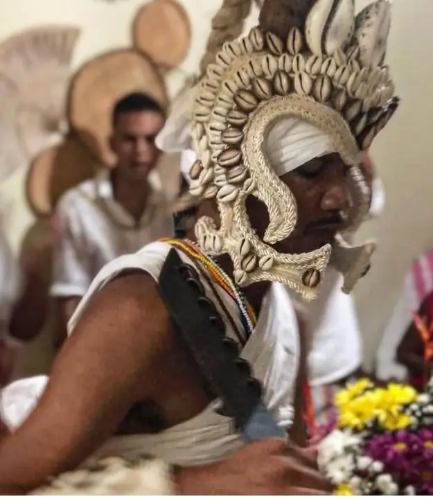 Ritual religioso com coroas elaboradas e flores coloridas.