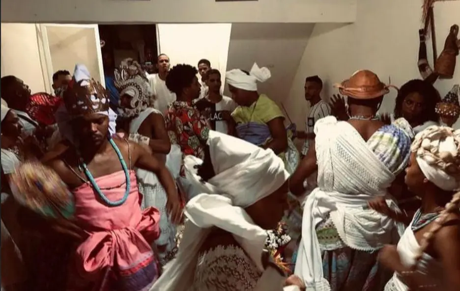 Cerimônia tradicional com dança e interação em trajes coloridos.