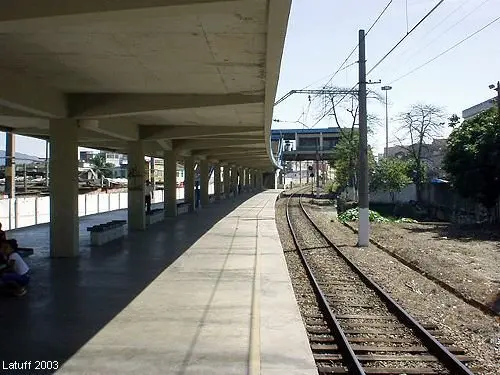 Plataforma de trem com pátio coberto e trilho ferroviário.