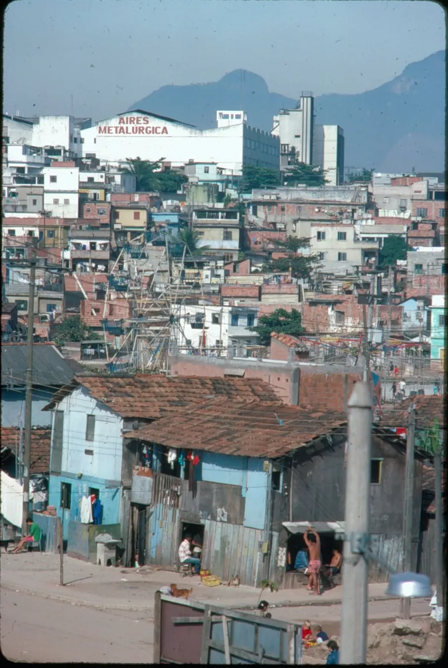 Área urbana com montanhas, edifícios industriais e residenciais.