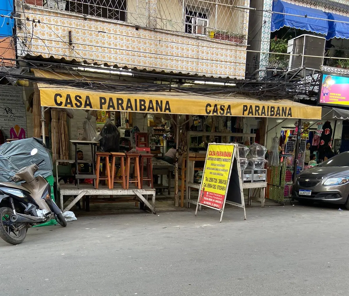 Loja urbana com motocicleta e banner amarelo.