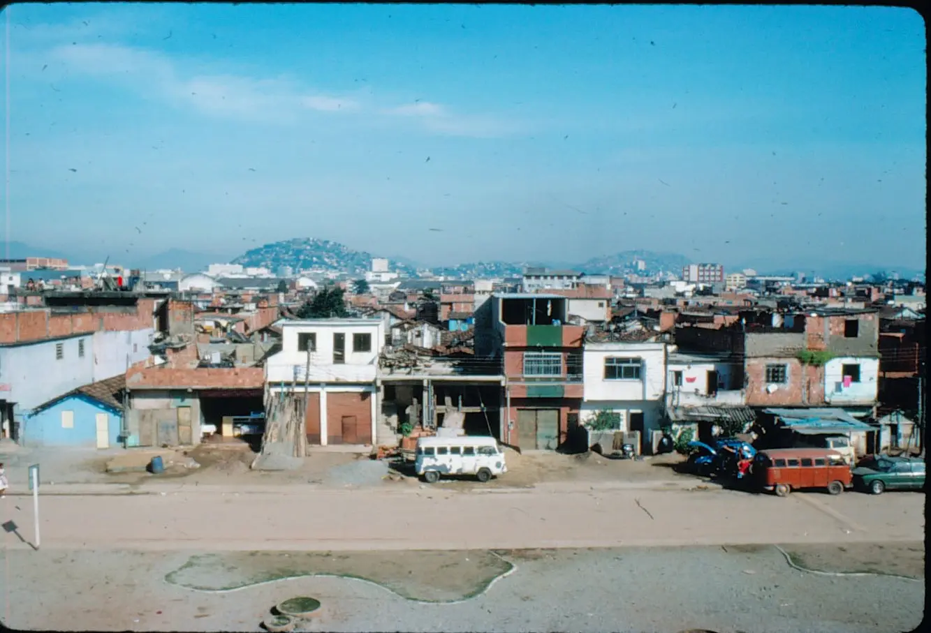 Imagem urbana com edifícios e veículo em destaque.