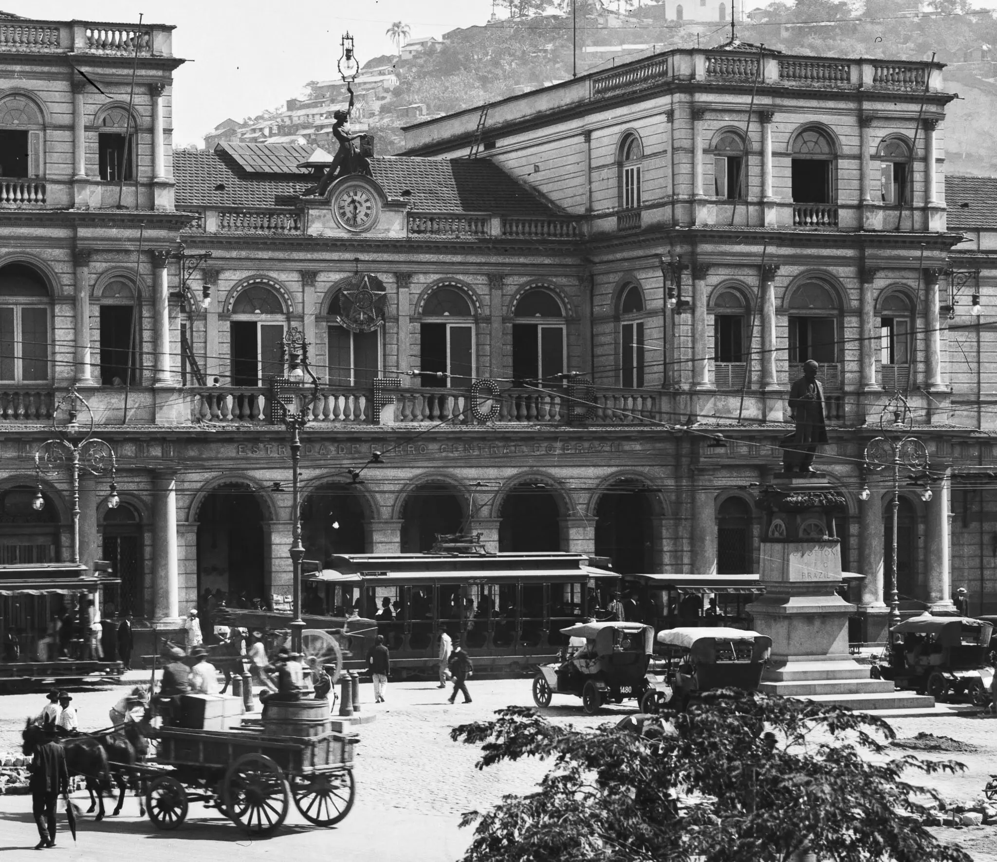 Edifício clássico com carruagem e monumento histórico.