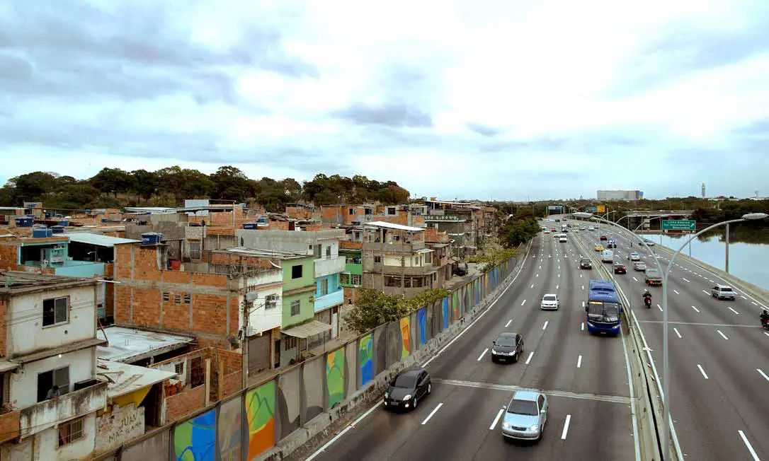 Via expressa com tráfego intenso e área residencial colorida.