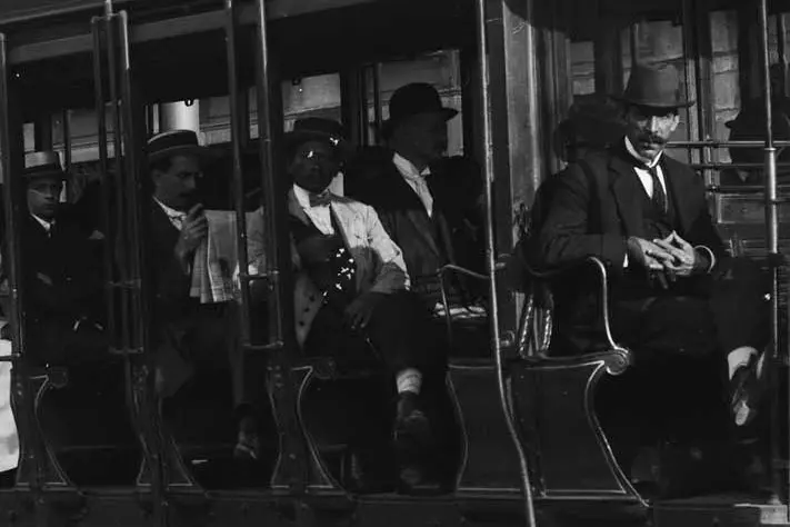 Cinco homens em ternos e chapéus em um trem.