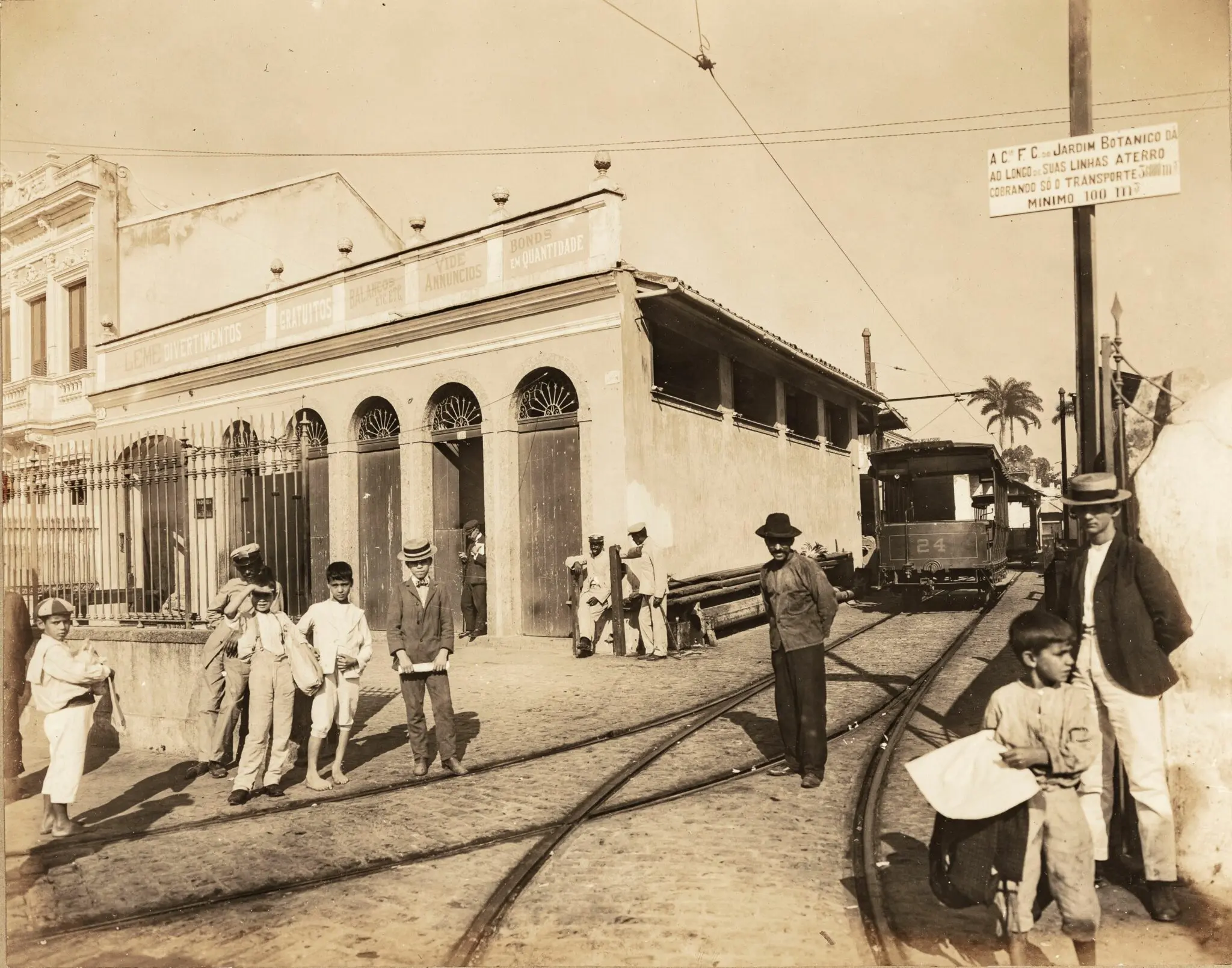Cena urbana antiga com pessoas, trem e edifício clássico.
