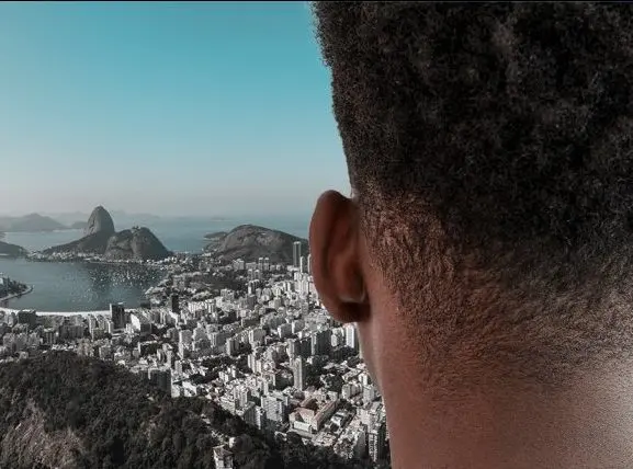 Cidade com vista panorâmica, rio, montanha piramidal, edifícios, céu azul claro.