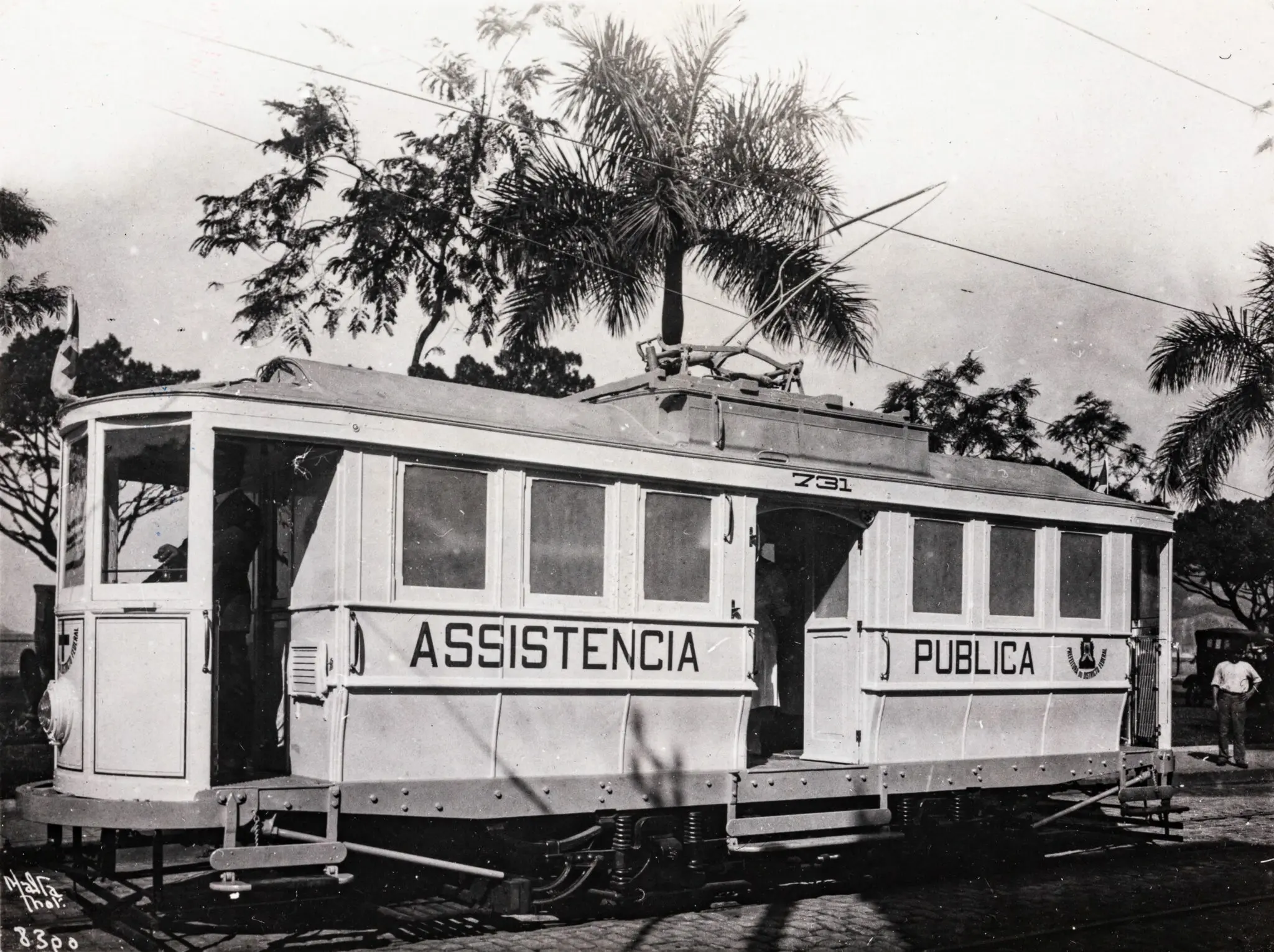 Bonde elétrico preto e branco, vista frontal com estrutura interna exposta.