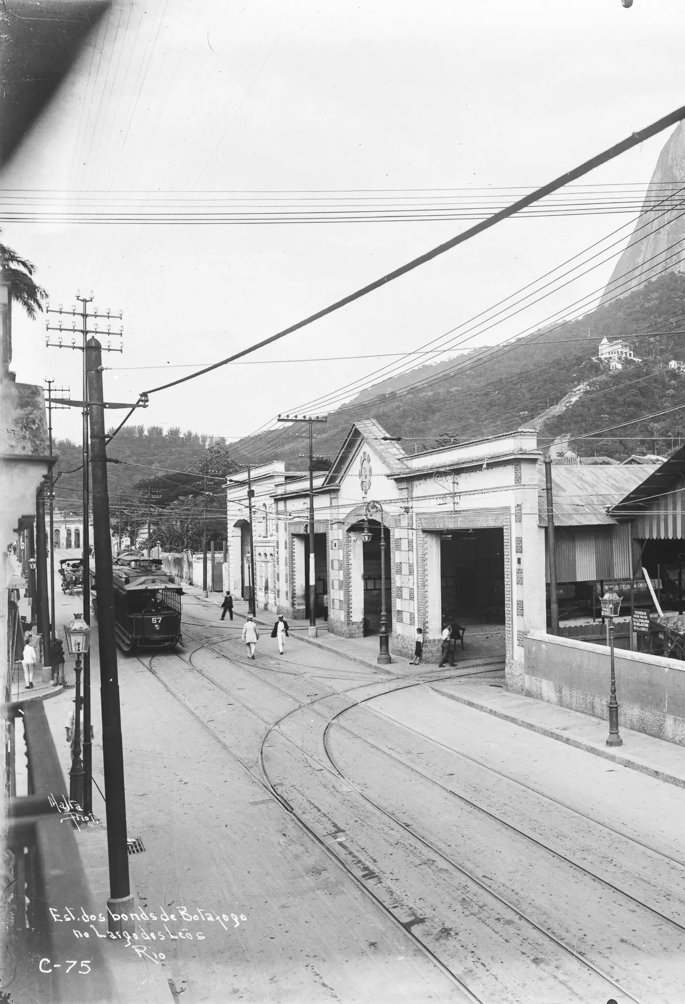Uma rua histórica com trilhos de bondes e construções ao fundo.