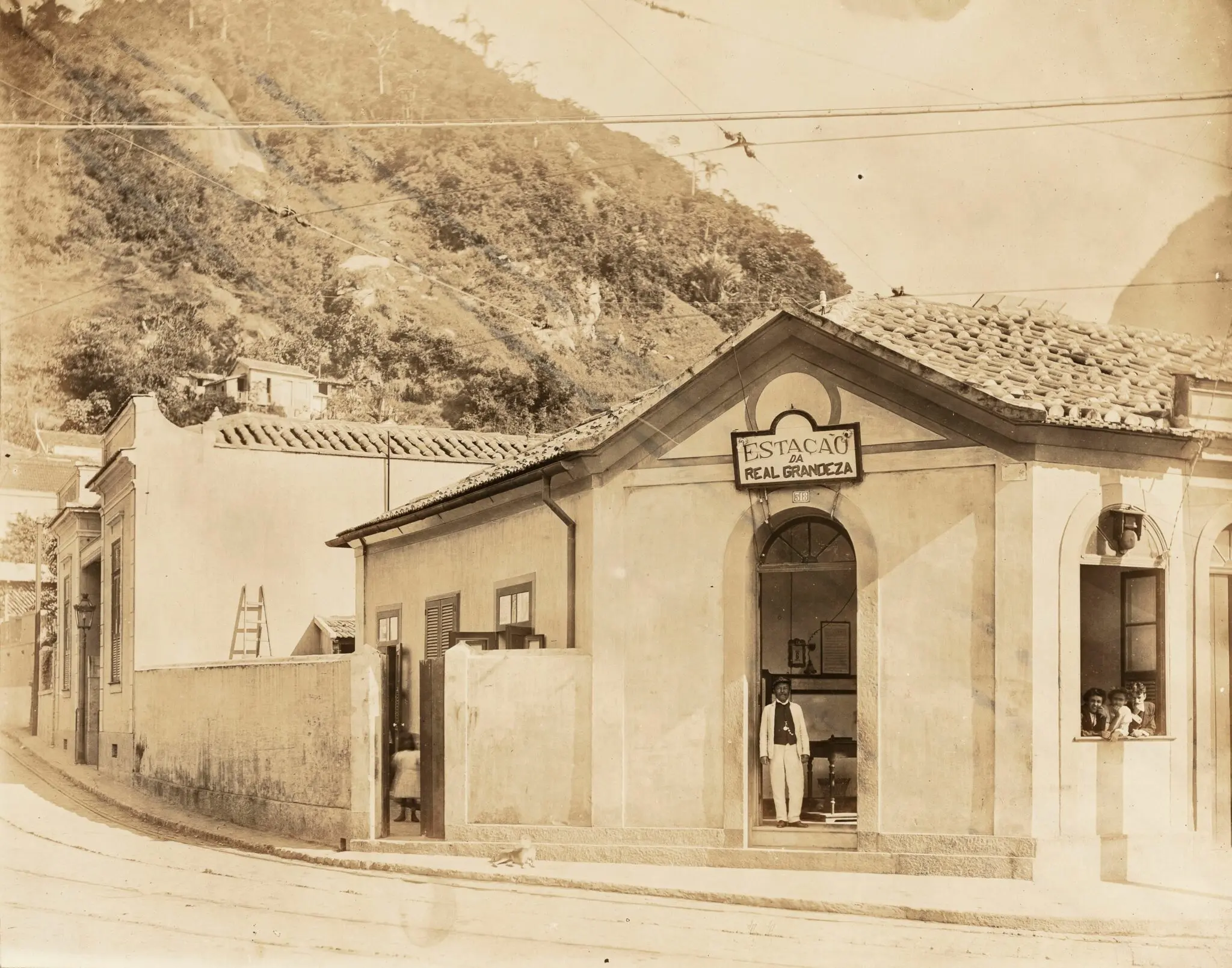 Fotografia antiga de estação antiga com pessoas e crianças.