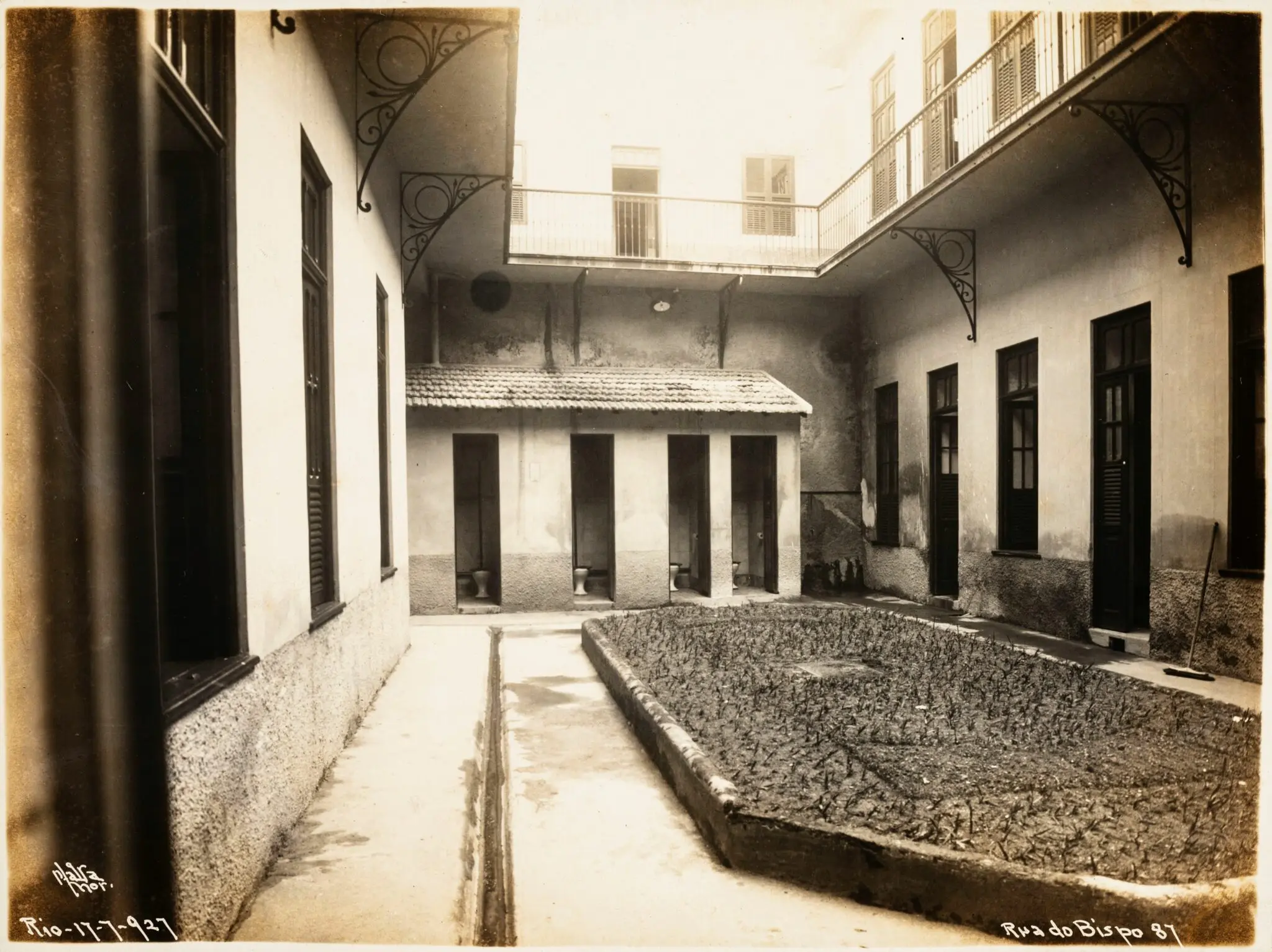 Pátio interno com construções antigas e data inscrita.