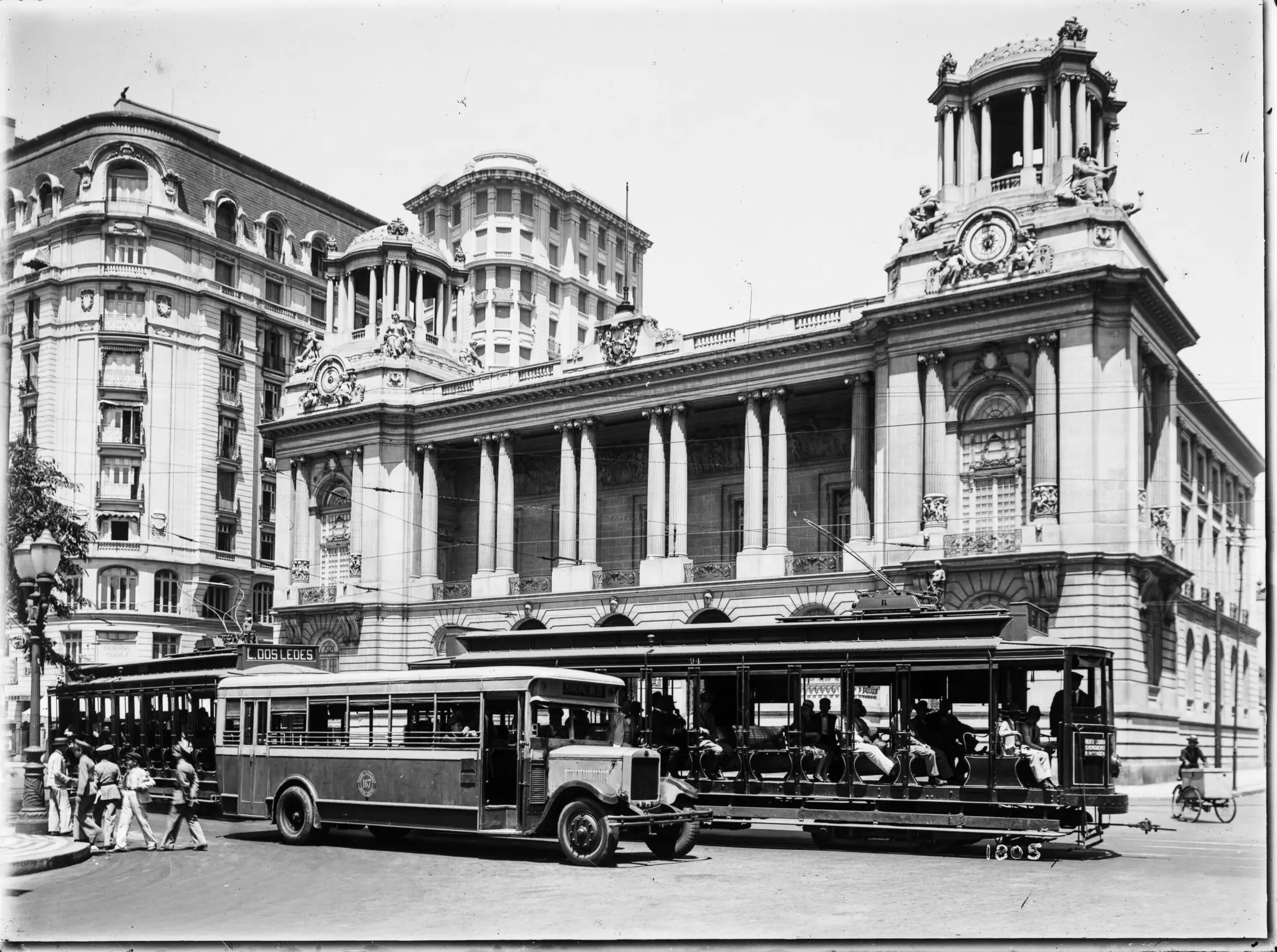 Ônibus antigo em frente a edifícios monumentais.