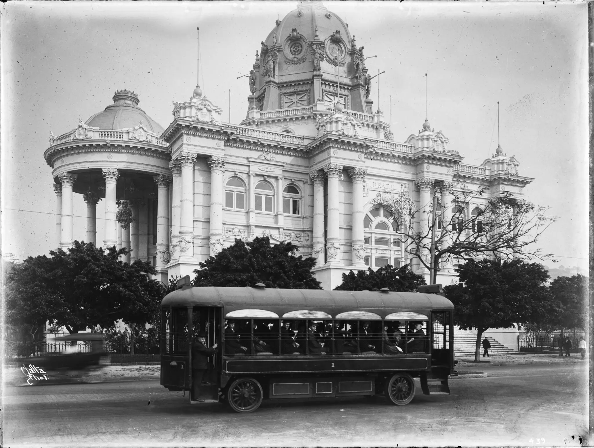 Ônibus antigo em frente a edifício clássico.