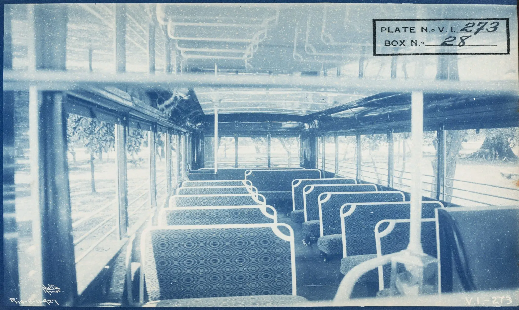 Ônibus antigo com assentos e janelas, paisagem ao fundo.