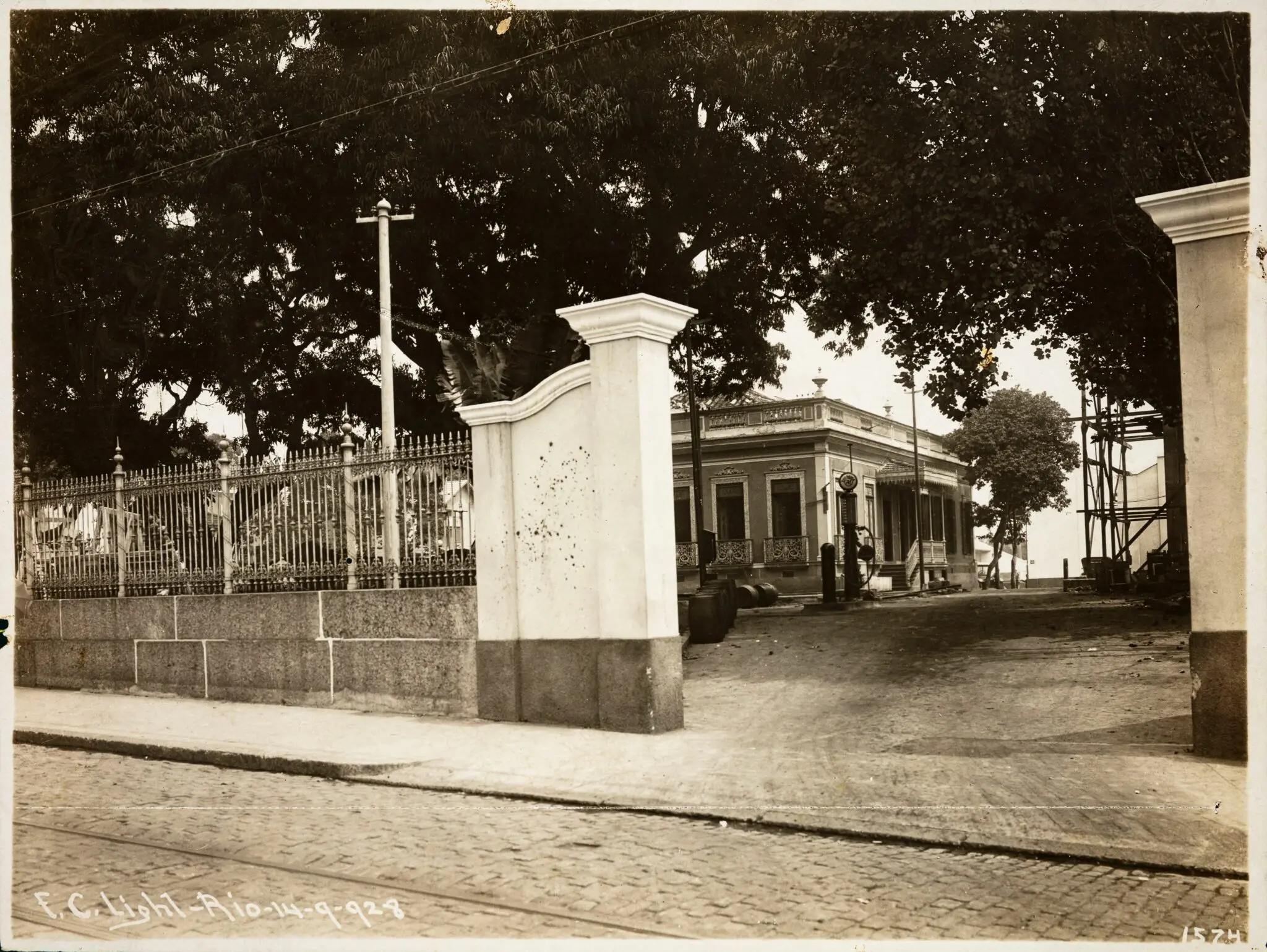 Uma foto antiga de área urbana com casa clássica e construção moderna.