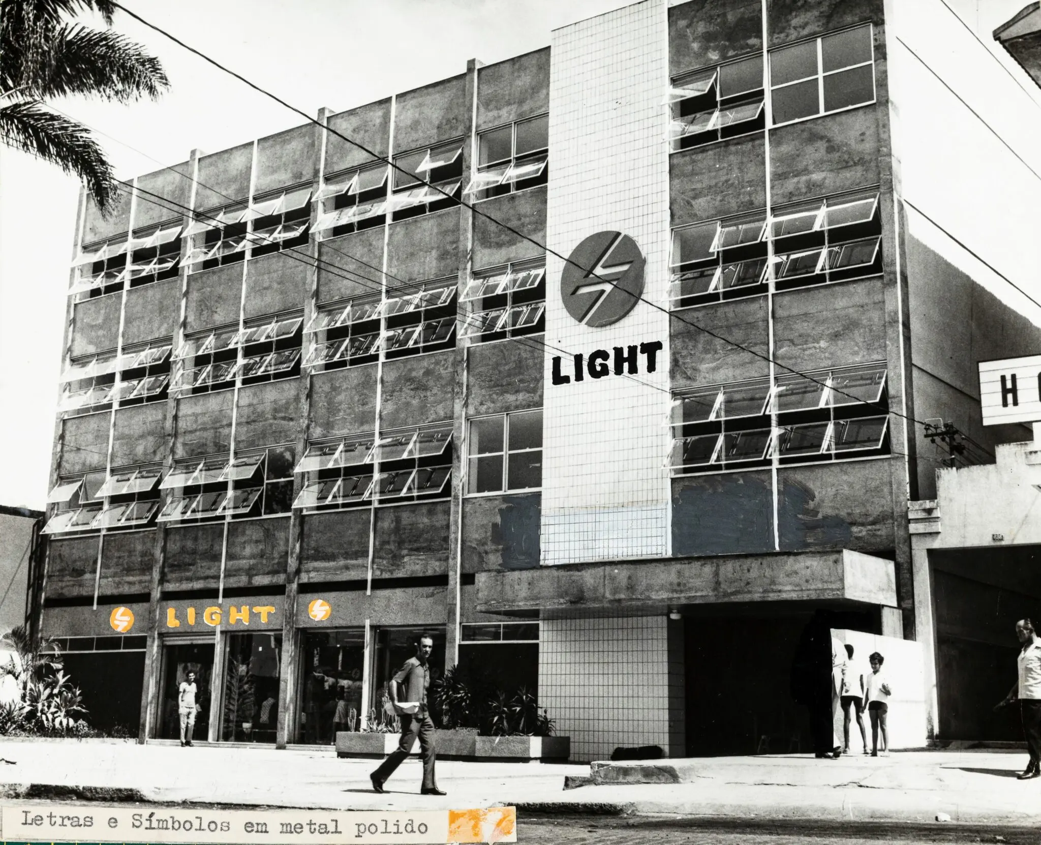Fachada de prédio comercial com logotipo da Light e pessoas caminhando.