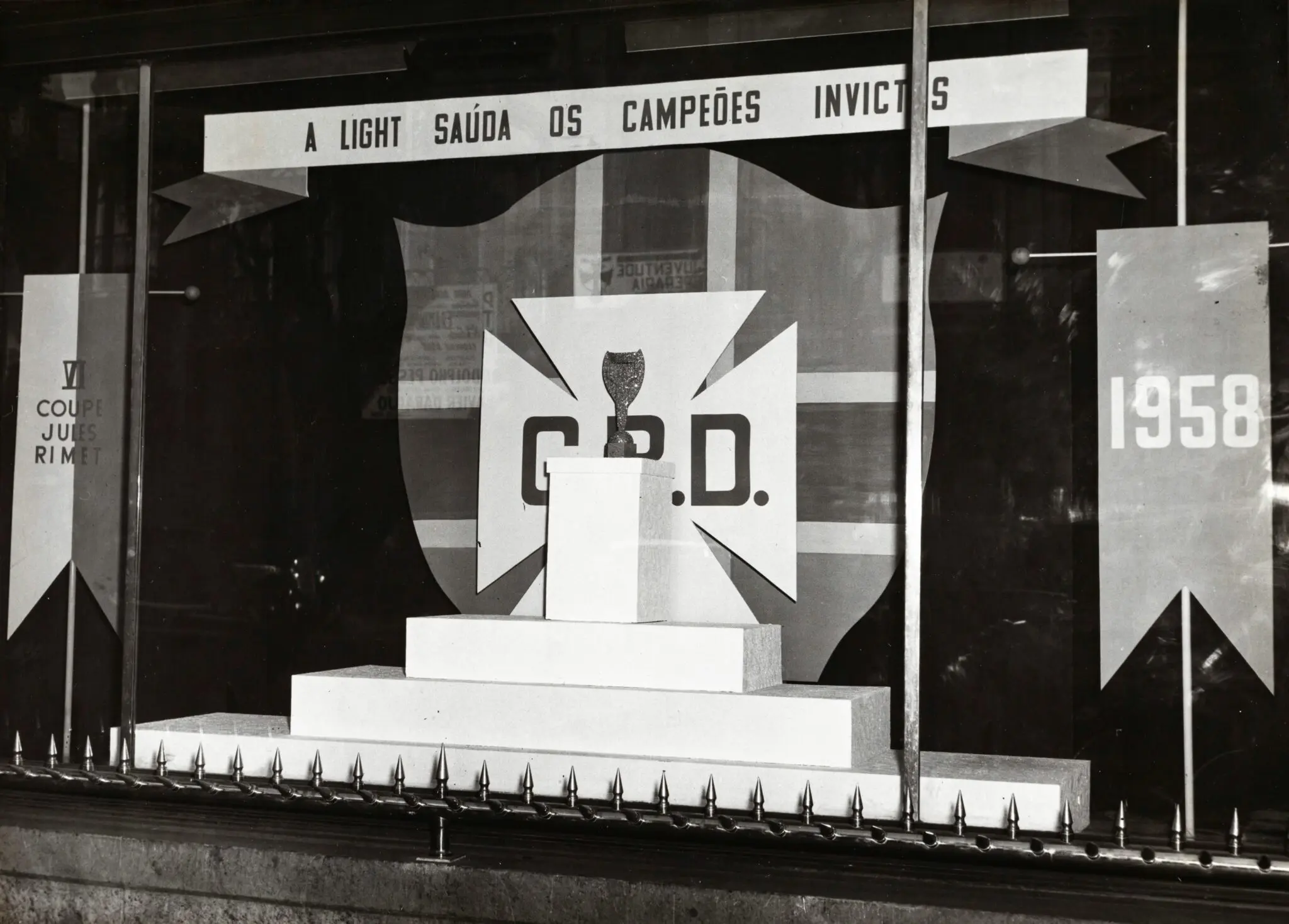 Vitrine comemorativa de 1958 exibindo troféu e painéis comemorativos.