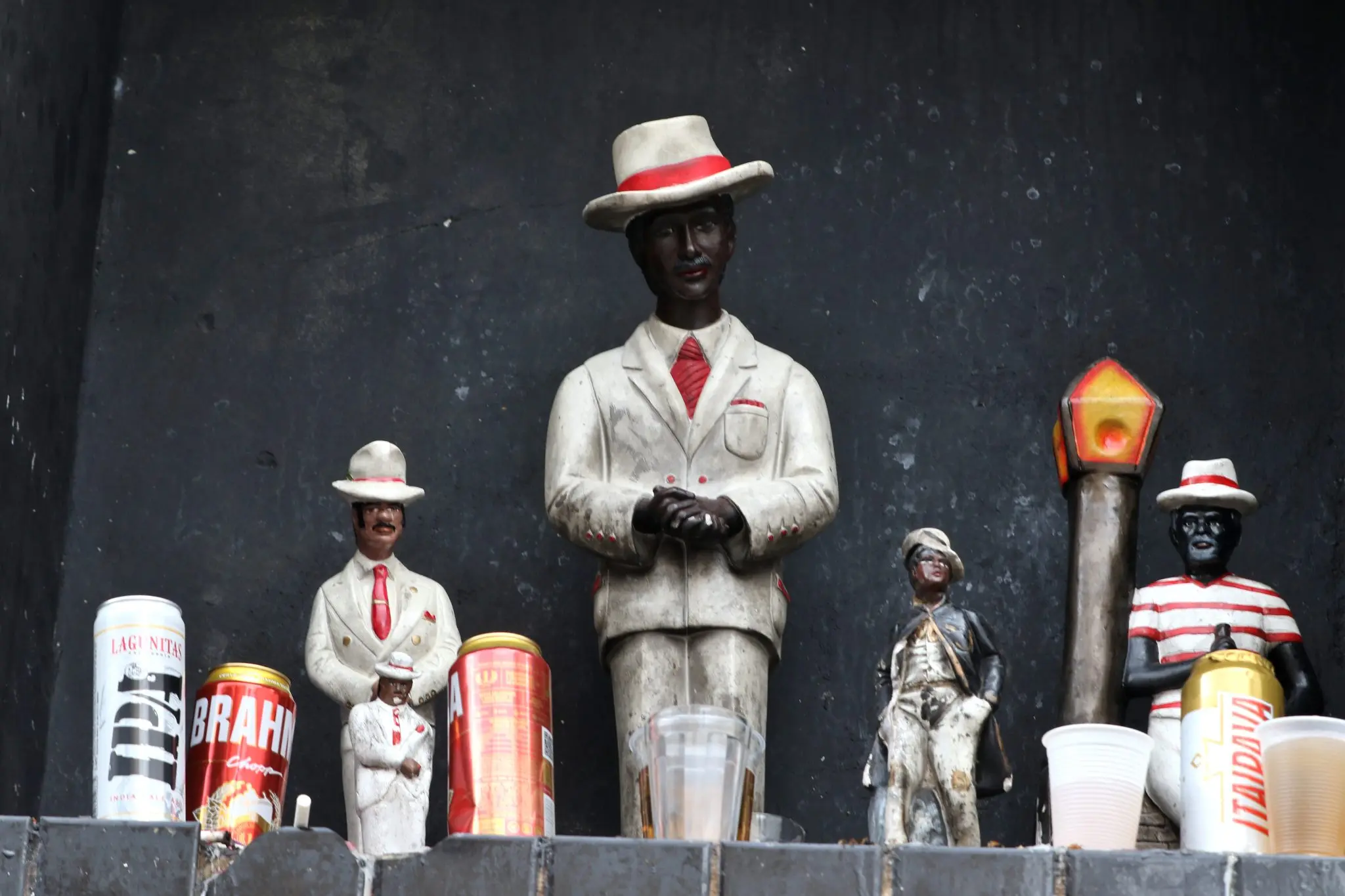 Coleção de miniaturas e latas de cerveja com figuras tradicionais.