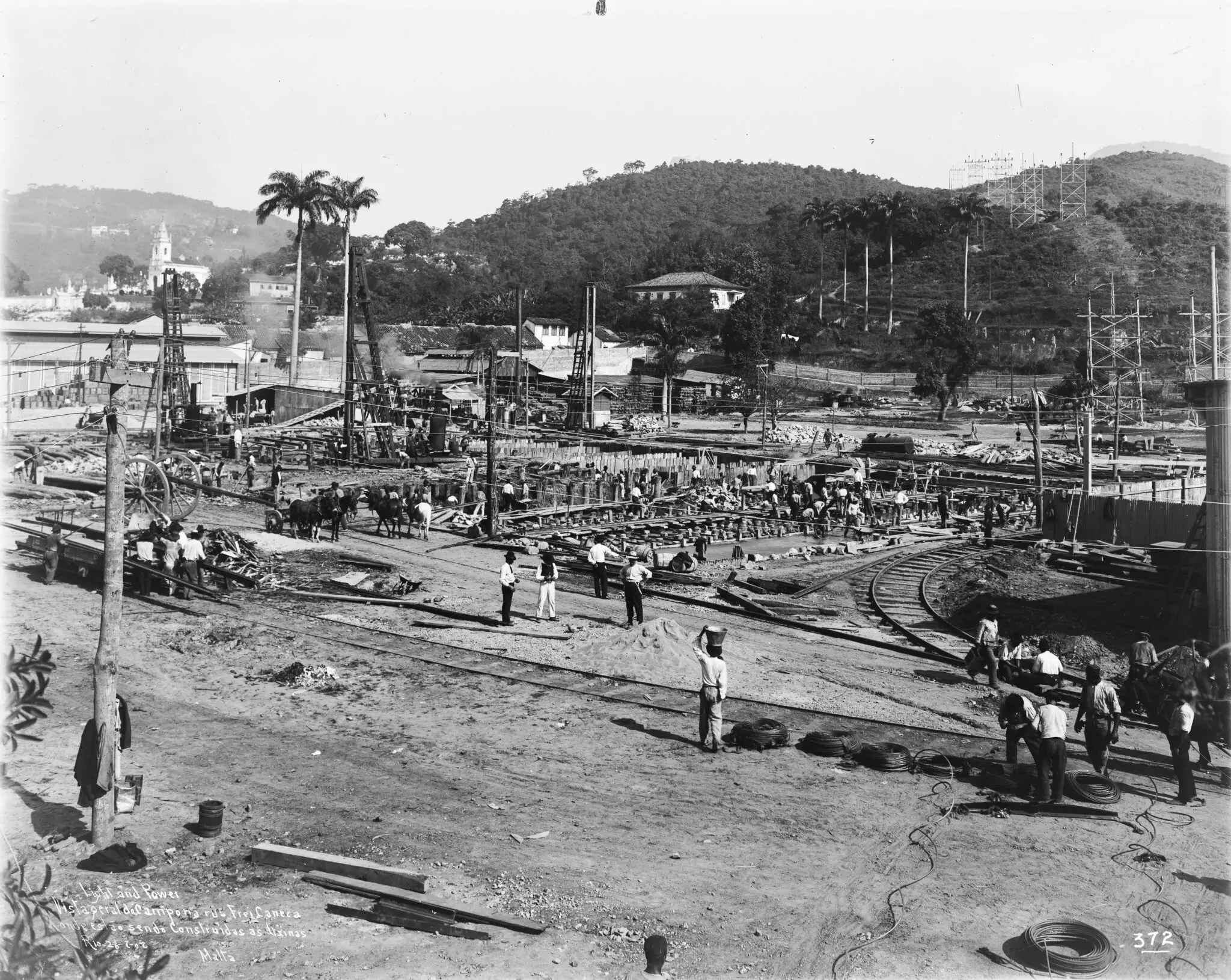 Área de construção com trabalhadores e estruturas de madeira.