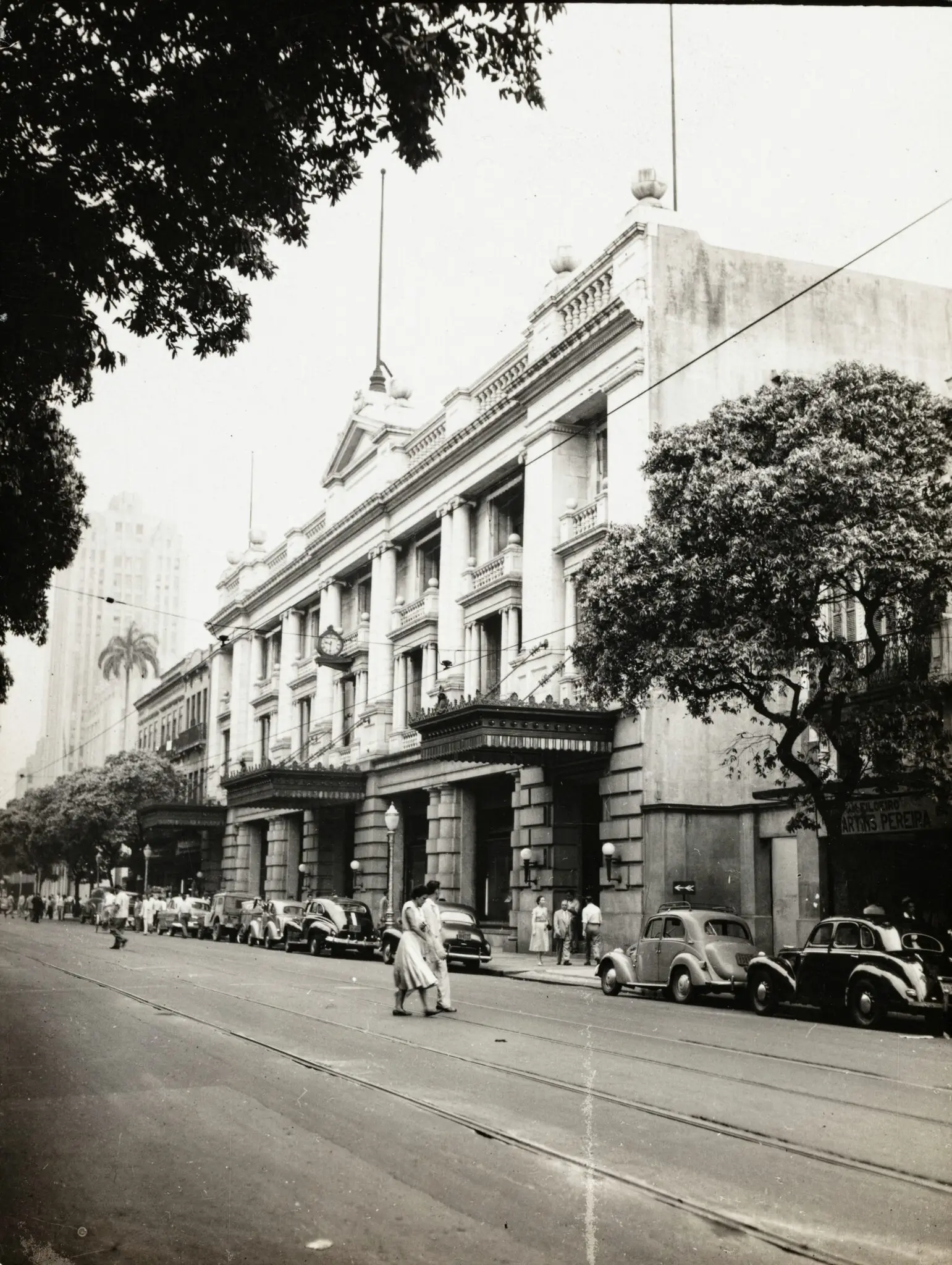 Edifício clássico com arquitetura monumental e árvores ao redor.