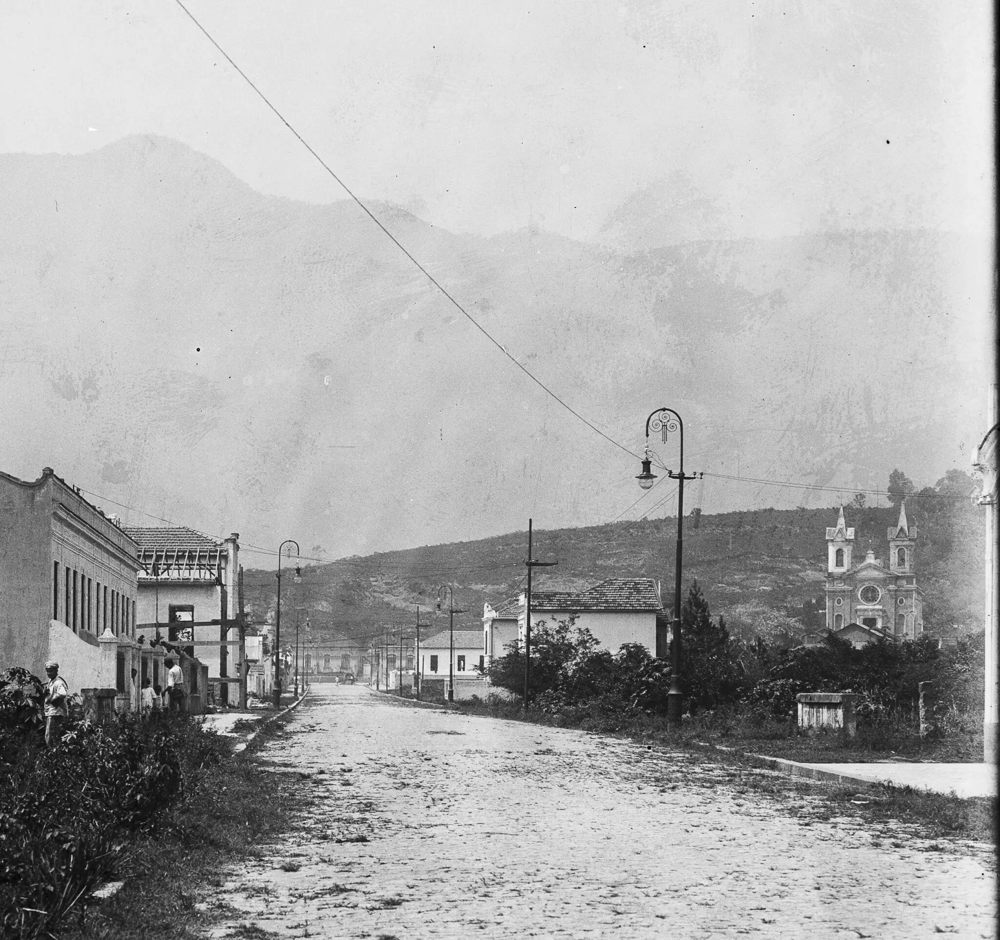 Uma rua urbana histórica com edifícios e montanhas.