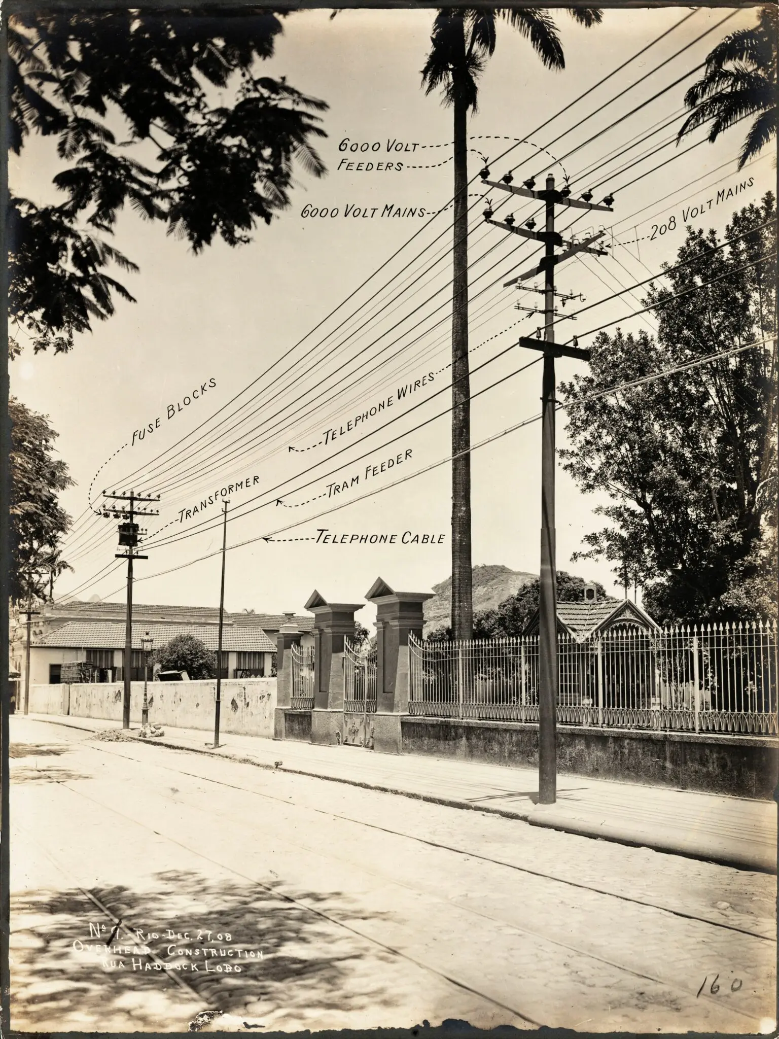 Uma rua antiga com linhas de energia elétrica e telefônicas.