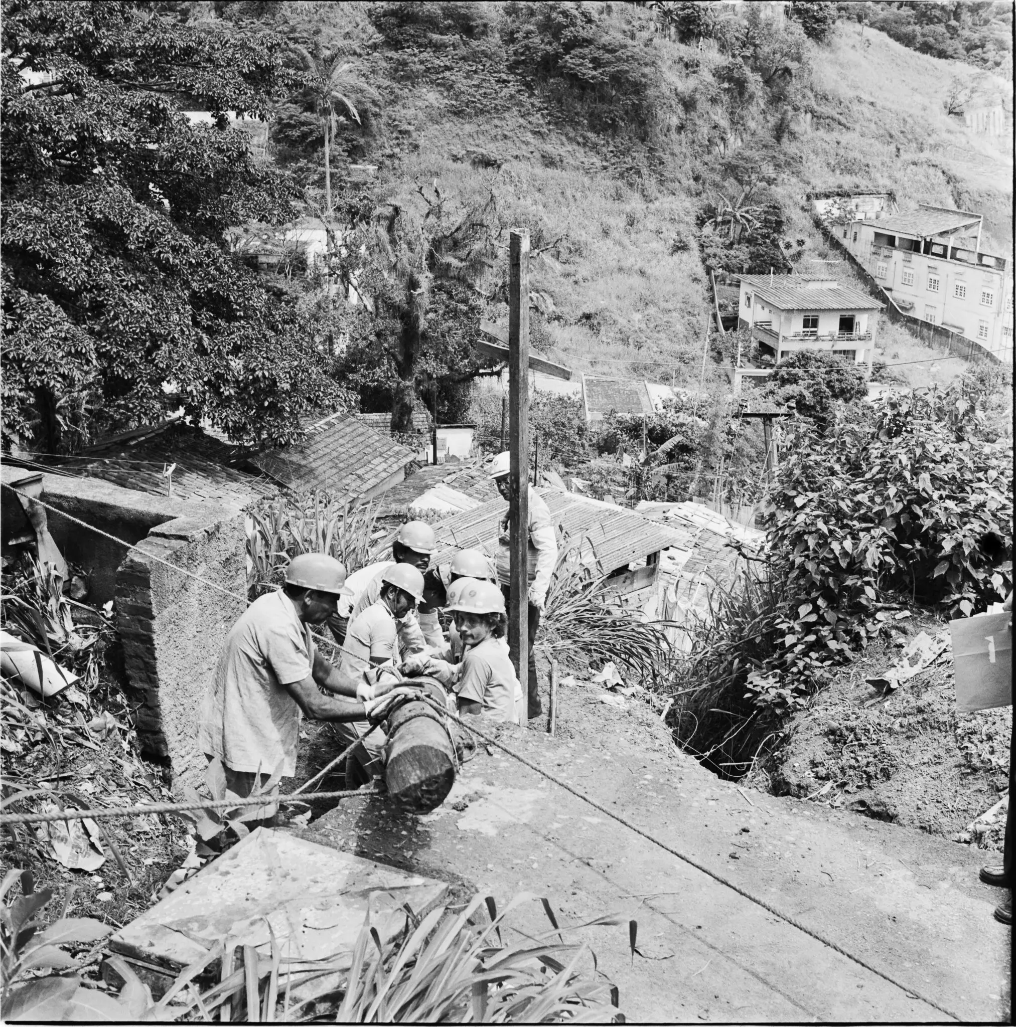 Trabalhadores em tarefas rurais, tijolos e madeira.