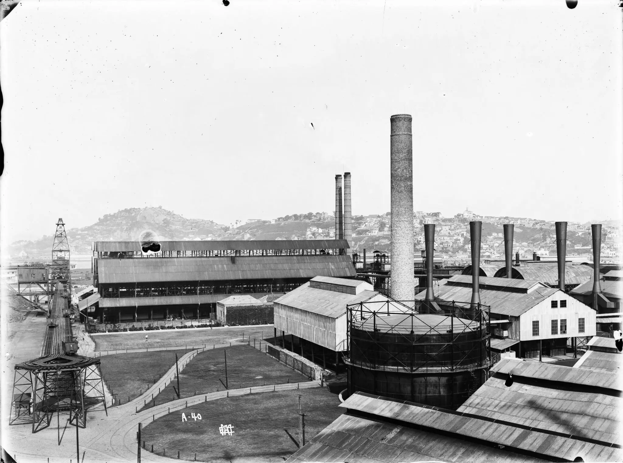 Fábrica de gás histórica vista de cima, com tanque circular e edifícios industriais.