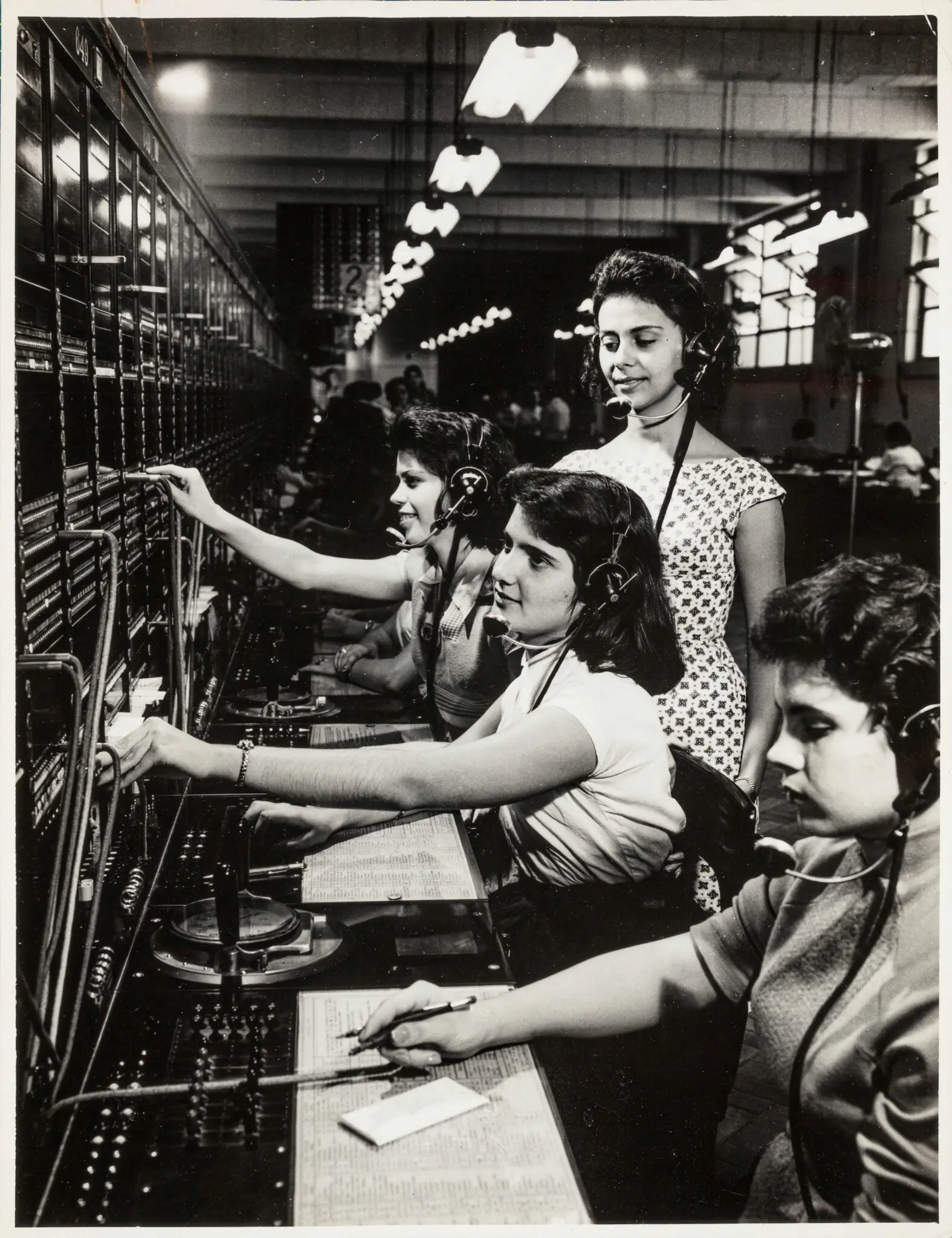 Mulheres trabalhando em estação telefônica, preto e branco.