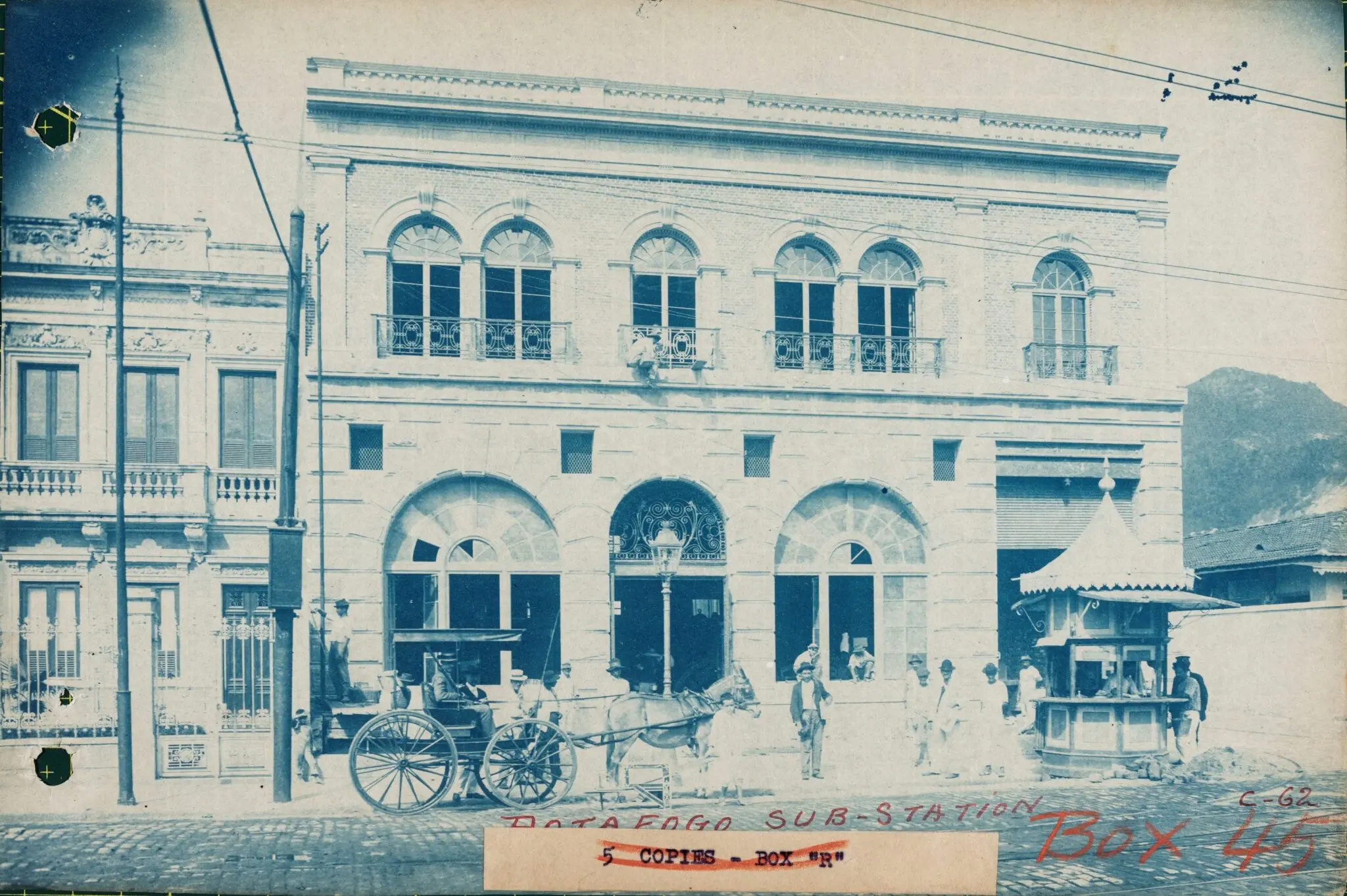Edifício clássico com carruagem e barraca móvel.