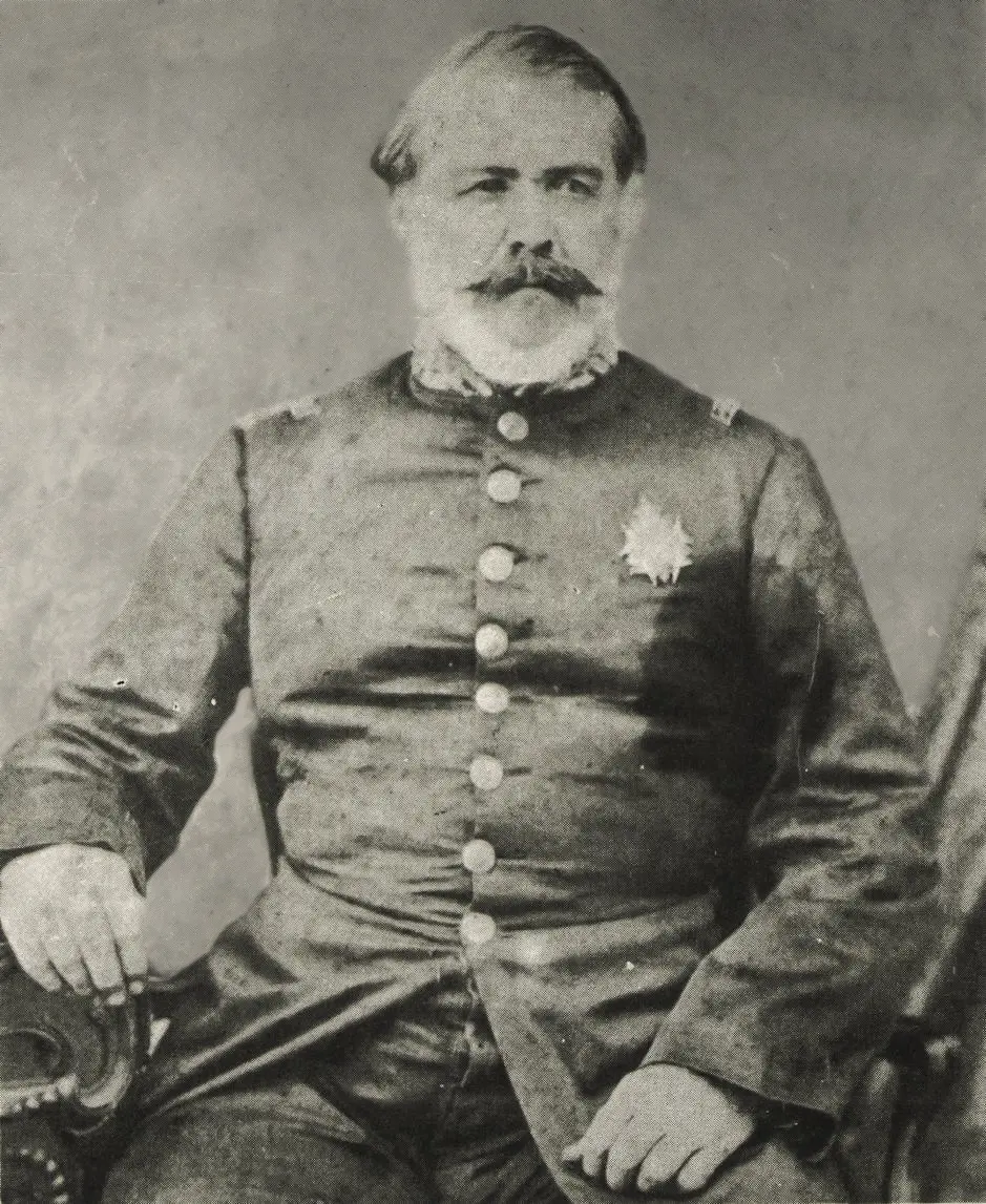 Homem militar antigo, uniforme, sentado, espada à mão, fundo neutro.