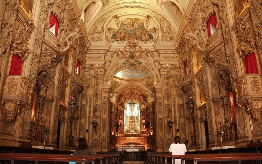 Interior de igreja com altar e detalhes ornamentais.