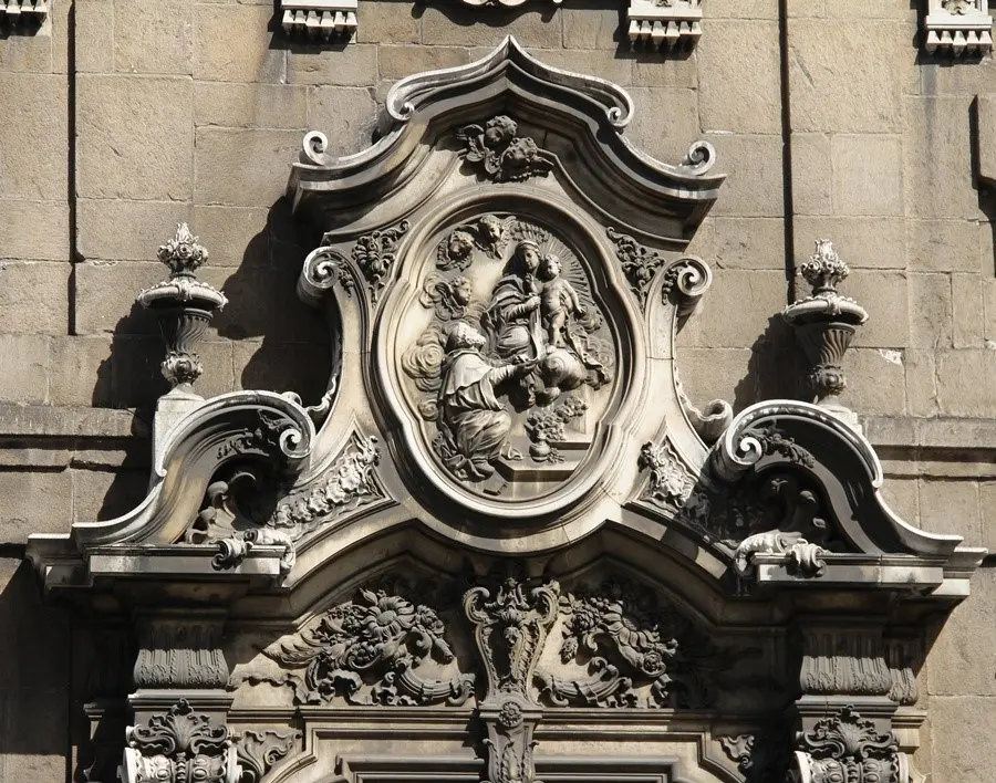 Detalhe arquitetônico de uma igreja com elementos decorativos em relevo.