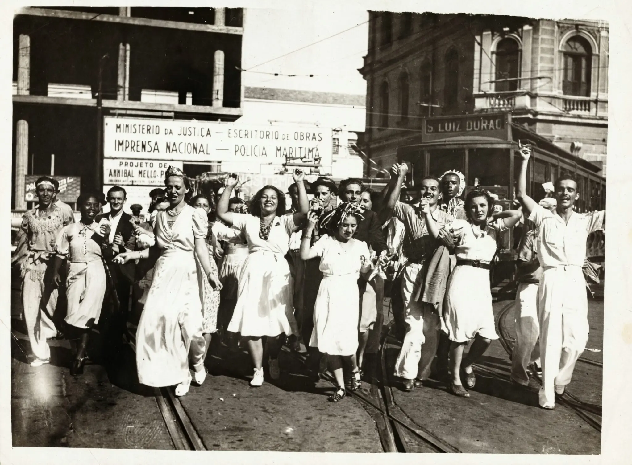 Grupo animado celebrando nas ruas, perto de edifícios governamentais.