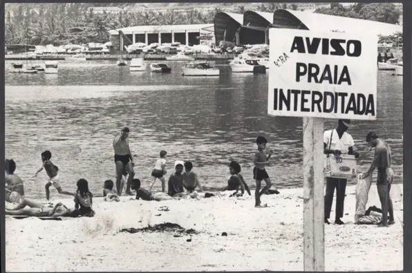 Praia lotada com interdição.