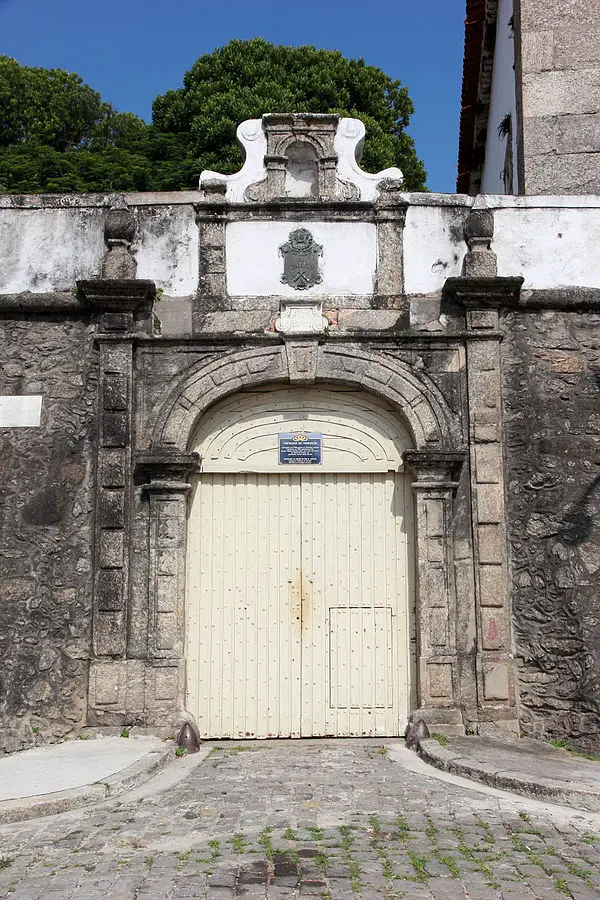 Entrada monumental de pedra com portal central e detalhes arquitetônicos.