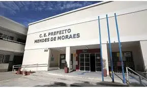 Prédio escolar com nome do colégio e escada metálica.