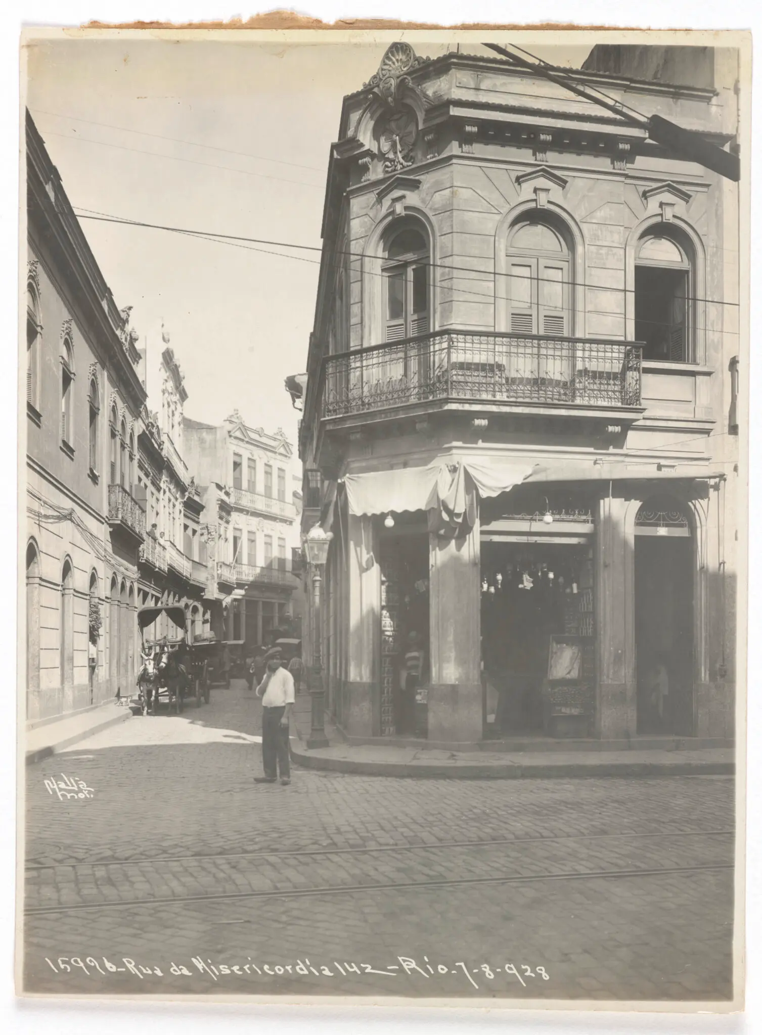 Fotografia histórica de rua com carruagem e edifício clássico em 1928.