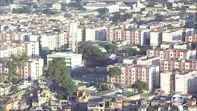 Área urbana densa com edifícios variados e vegetação verde.