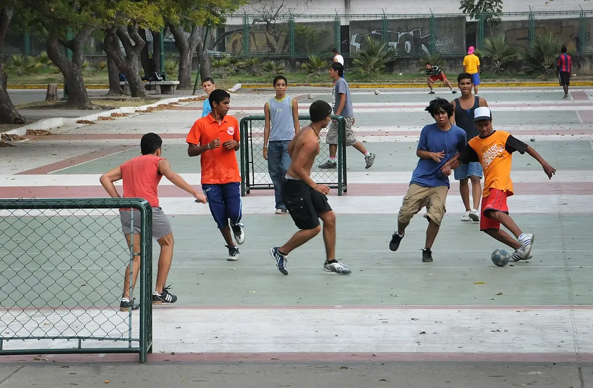Jogadores de futebol de rua em campo concreto.
