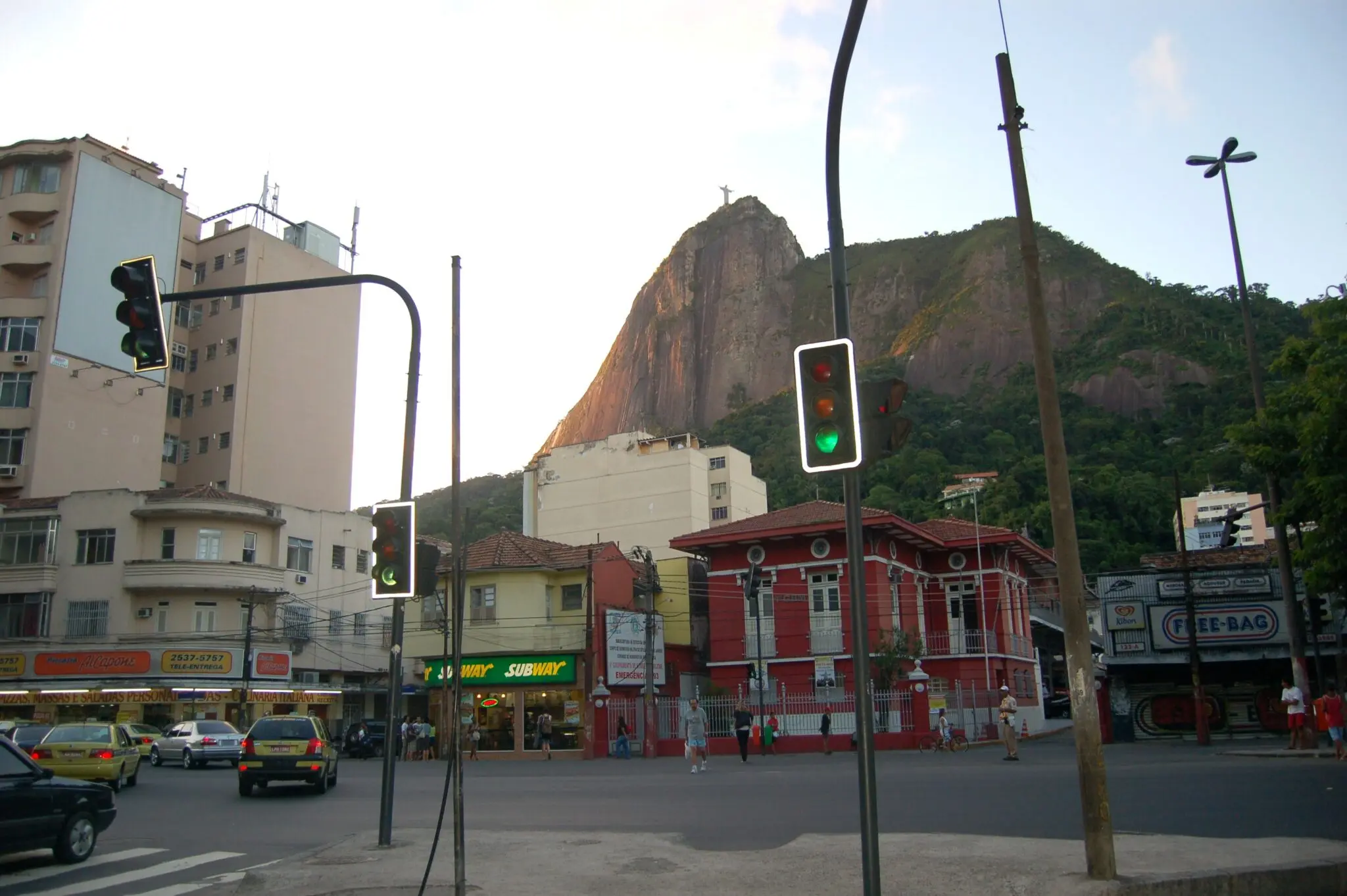 RUA URBANA COM EDIFÍCIOS COLORIDOS E RESTAURANTE SUBWAY AO FUNDO.
