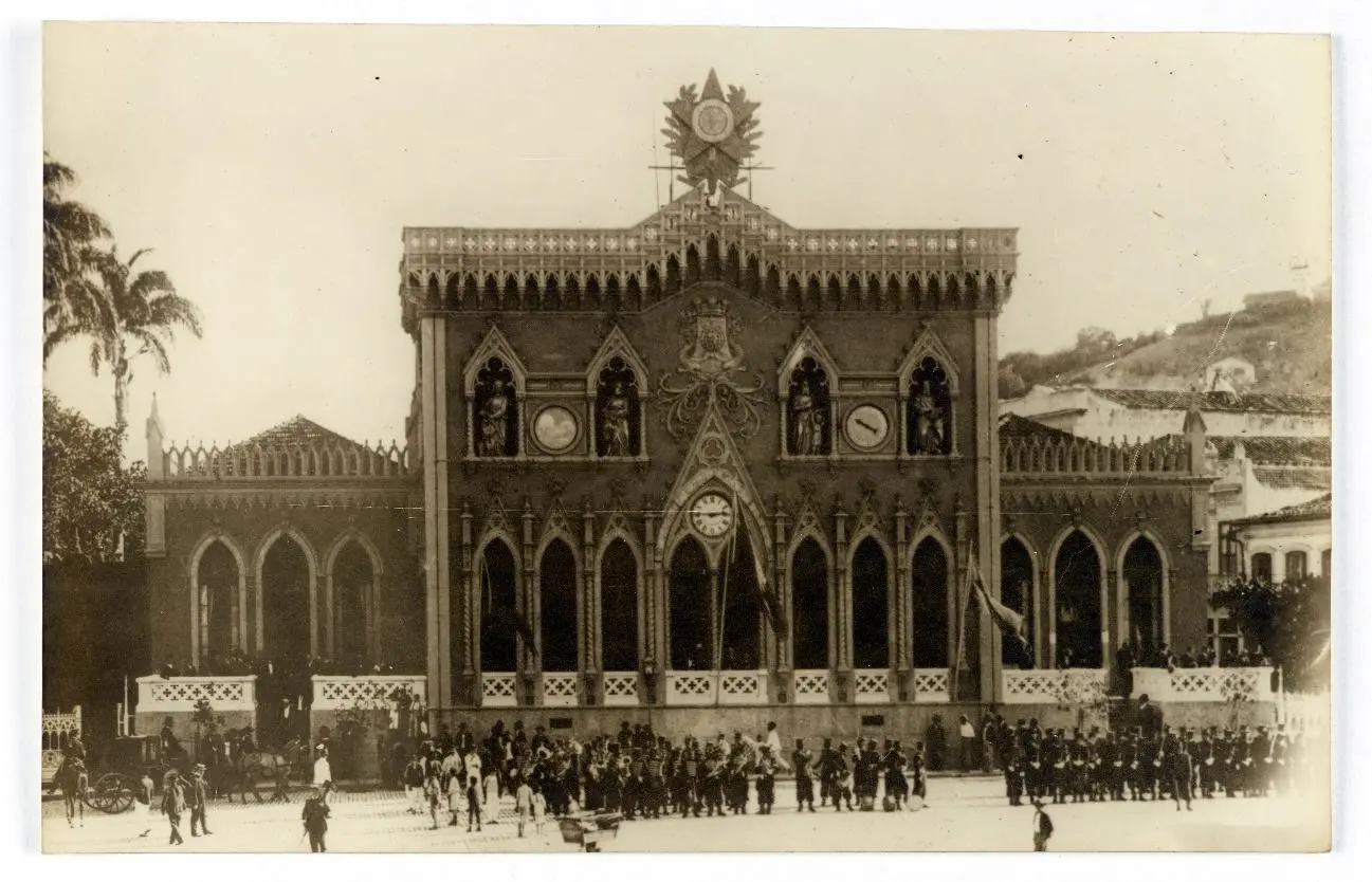 Palácio neogótico com multidão em formação militar.