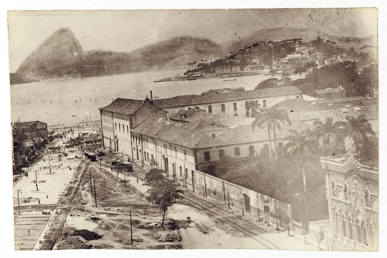 Cidade costeira com montanhas, rio, palmeiras e edifícios históricos.